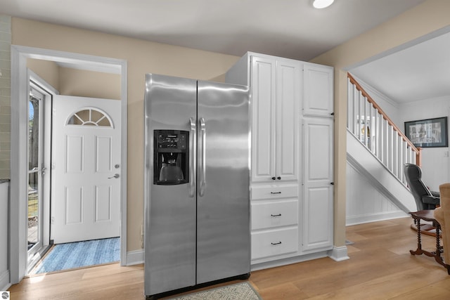 1750 S Schneider St, Lake City, MI 49651 - kitchen with stainless steel fridge, light wood-type flooring, white cabinets, and baseboards