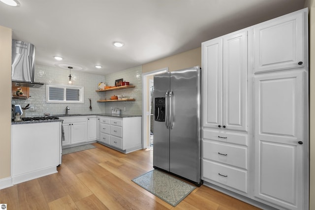 1750 S Schneider St, Lake City, MI 49651 - kitchen featuring stainless steel refrigerator with ice dispenser, open shelves, extractor fan, light wood-style floors, and white cabinets