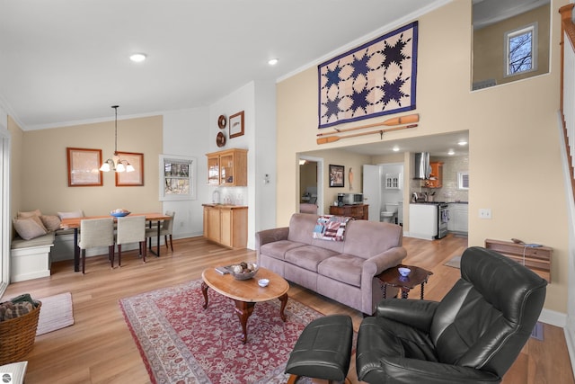 1750 S Schneider St, Lake City, MI 49651 - living room with ornamental molding, a chandelier, light wood finished floors, high vaulted ceiling, and baseboards
