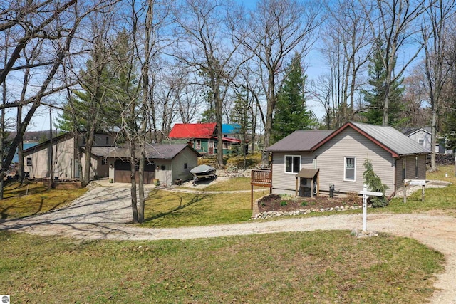 1750 S Schneider St, Lake City, MI 49651 - view of front of home featuring driveway, a front yard, metal roof, and a deck