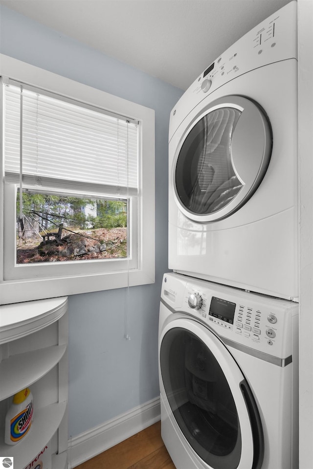 1750 S Schneider St, Lake City, MI 49651 - laundry room with stacked washing machine and dryer, baseboards, and wood finished floors