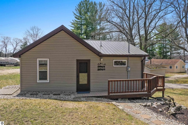 1750 S Schneider St, Lake City, MI 49651 - view of front of house with a wooden deck, a front lawn, and metal roof