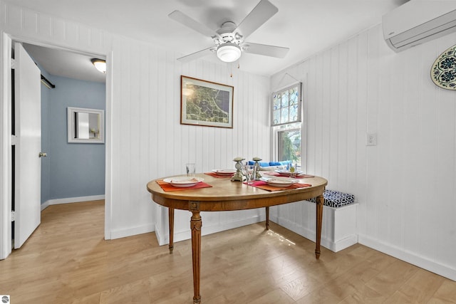 1750 S Schneider St, Lake City, MI 49651 - dining room featuring an AC wall unit, light wood-type flooring, ceiling fan, and baseboards