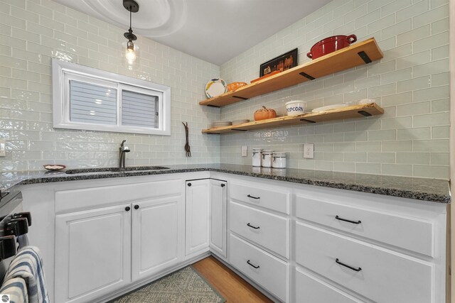 1750 S Schneider St, Lake City, MI 49651 - kitchen with backsplash, a sink, white cabinets, and dark stone countertops