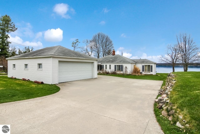 12225 SW Torch Lake Dr SW, Rapid City, MI 49676 - view of front of property with an outdoor structure, a garage, a front yard, and a water view