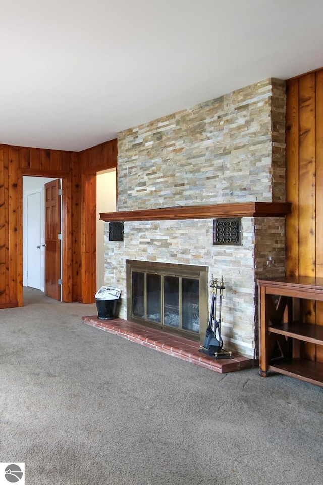 12225 SW Torch Lake Dr SW, Rapid City, MI 49676 - unfurnished living room featuring a fireplace, carpet flooring, and wooden walls