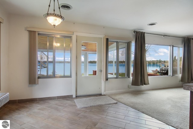 12225 SW Torch Lake Dr SW, Rapid City, MI 49676 - doorway featuring a water view and baseboards
