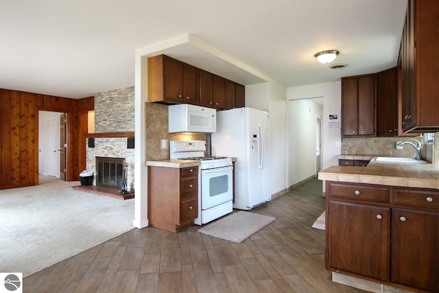 12225 SW Torch Lake Dr SW, Rapid City, MI 49676 - kitchen featuring white appliances, a sink, tasteful backsplash, and tile counters