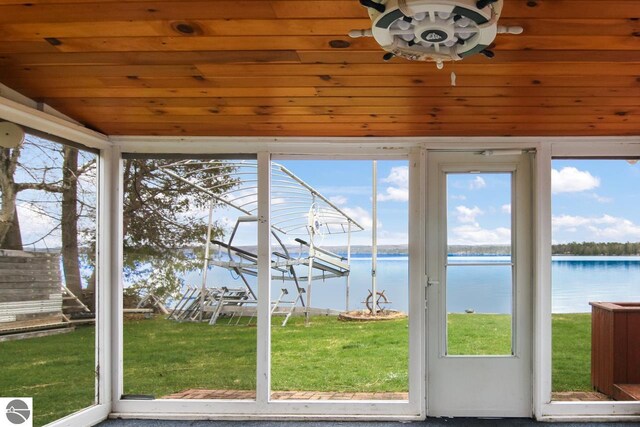 12225 SW Torch Lake Dr SW, Rapid City, MI 49676 - unfurnished sunroom featuring a water view, healthy amount of natural light, and vaulted ceiling