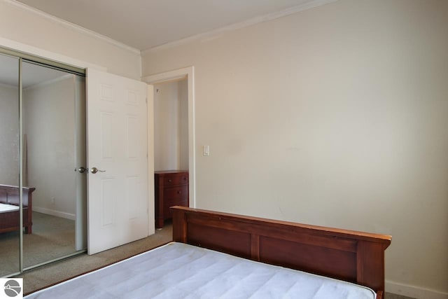 12225 SW Torch Lake Dr SW, Rapid City, MI 49676 - bedroom featuring carpet, crown molding, a closet, and baseboards