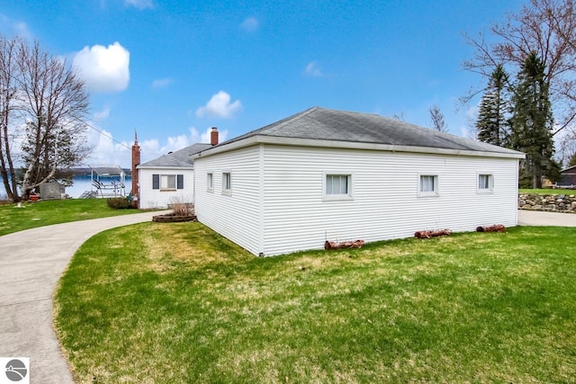 12225 SW Torch Lake Dr SW, Rapid City, MI 49676 - view of side of property featuring a yard and a shingled roof