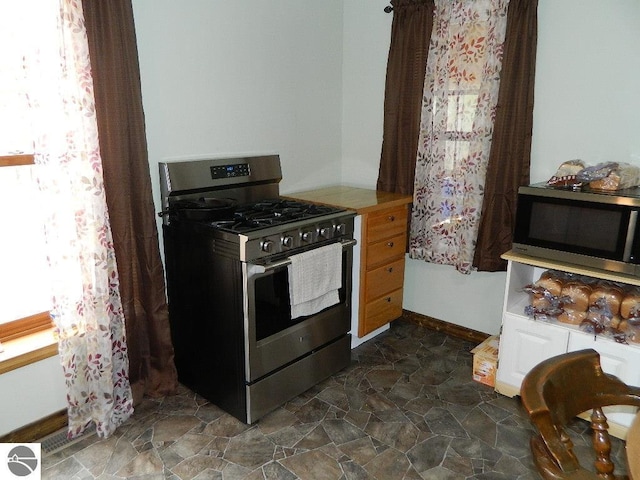 kitchen with stainless steel appliances and dark stone finish flooring