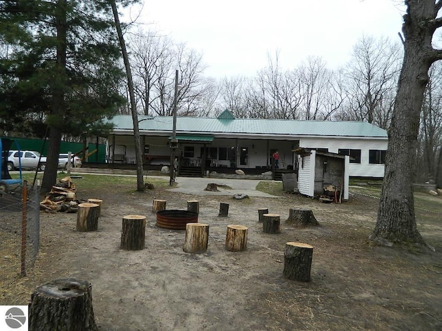 rear view of house featuring metal roof and a porch