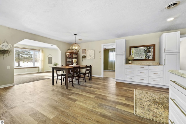 8481 E Houghton Lake Rd, Merritt, MI 49667 - dining space with wood finished floors, a textured ceiling, baseboards, and a chandelier