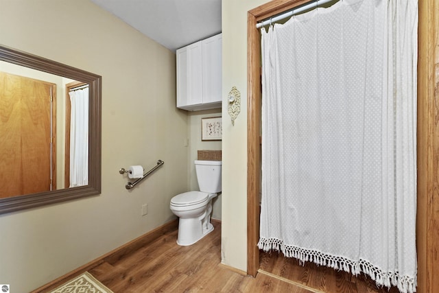 8481 E Houghton Lake Rd, Merritt, MI 49667 - full bath with wood finished floors, toilet, curtained shower, and baseboards