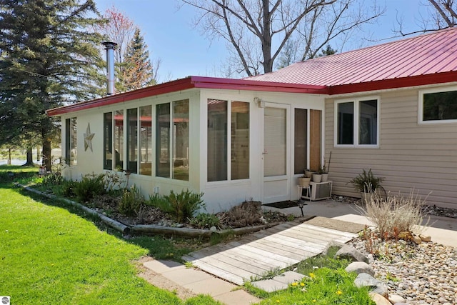 8481 E Houghton Lake Rd, Merritt, MI 49667 - rear view of property with a sunroom, metal roof, and a yard