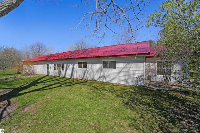 8481 E Houghton Lake Rd, Merritt, MI 49667 - back of property featuring a lawn and metal roof