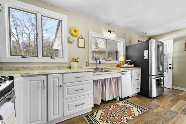 8481 E Houghton Lake Rd, Merritt, MI 49667 - kitchen with freestanding refrigerator, a sink, white cabinetry, dark wood-style flooring, and light countertops