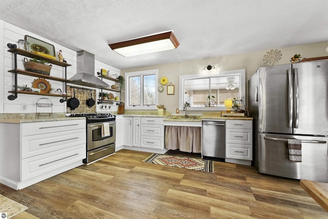 8481 E Houghton Lake Rd, Merritt, MI 49667 - kitchen featuring stainless steel appliances, open shelves, a sink, wall chimney range hood, and light wood-style flooring