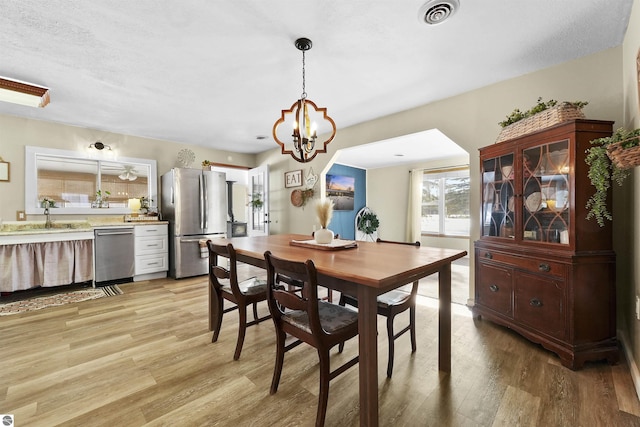 8481 E Houghton Lake Rd, Merritt, MI 49667 - dining area featuring light wood-type flooring and a chandelier