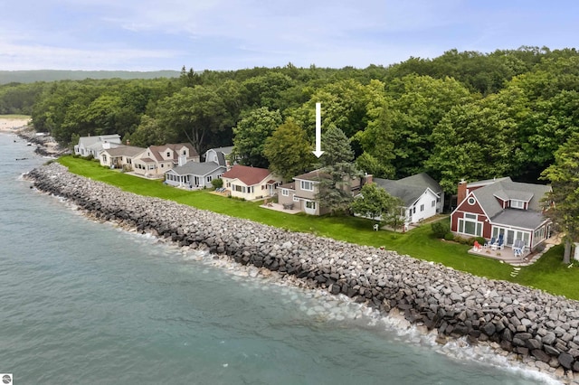 drone / aerial view of a nearby body of water and a forest