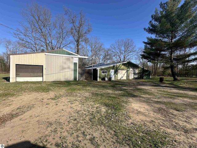 view of yard featuring a garage and an outbuilding