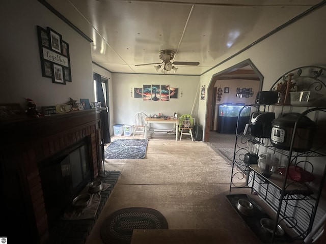 living room featuring ceiling fan, a brick fireplace, and arched walkways