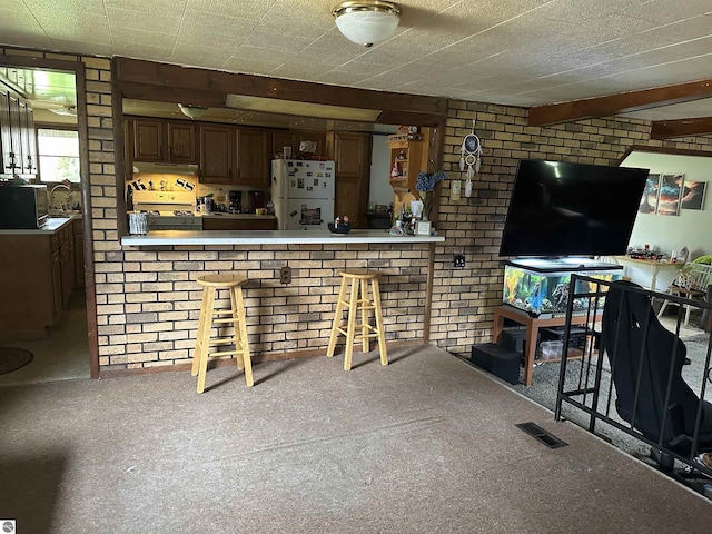 living room featuring carpet and brick wall