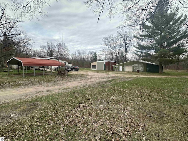 view of yard with a garage, driveway, and an outdoor structure