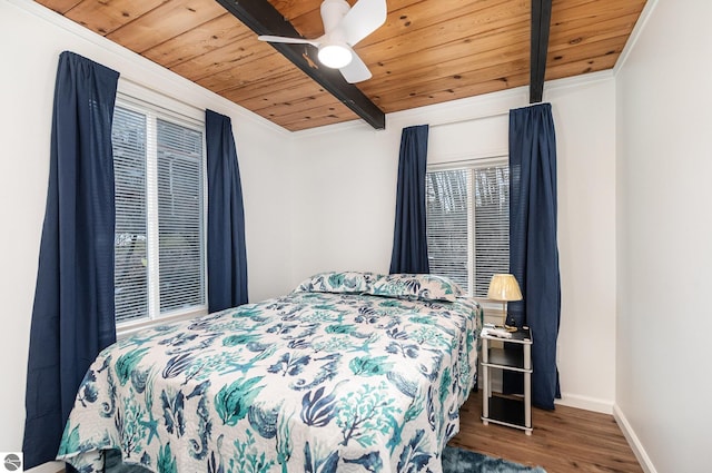 bedroom featuring wood ceiling, wood finished floors, baseboards, and a ceiling fan