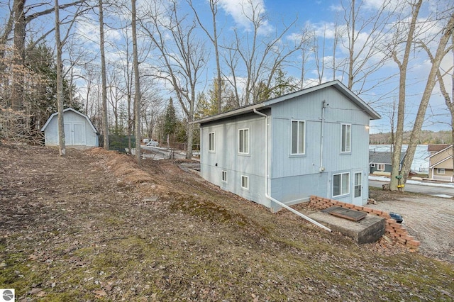 view of property exterior with a storage shed and an outbuilding