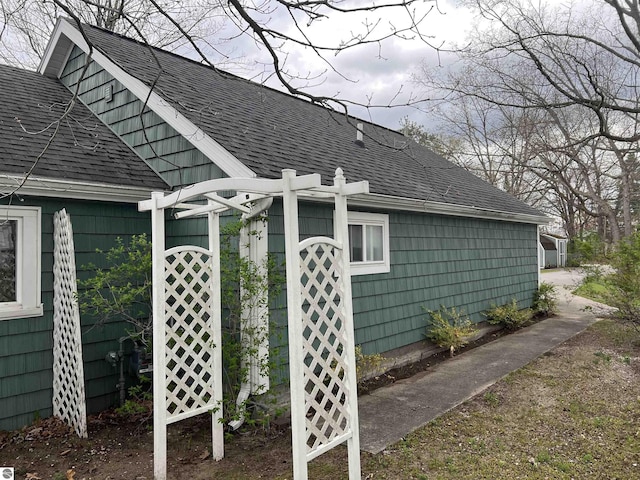 view of side of home featuring roof with shingles