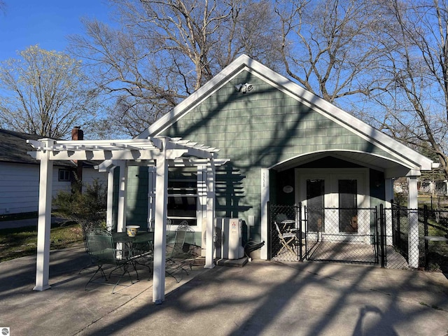 view of front of house with a gate, a pergola, fence, and a patio