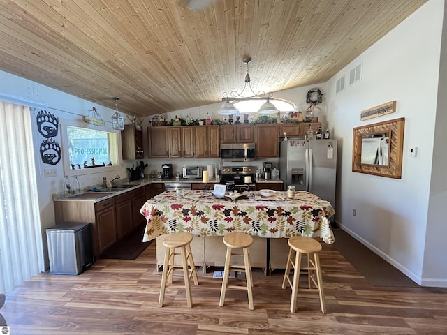 15831 SE M 72, Grayling, MI 49738 - kitchen with appliances with stainless steel finishes, a sink, a breakfast bar, light countertops, and wooden ceiling