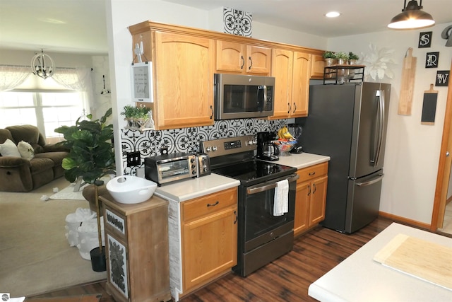 kitchen with appliances with stainless steel finishes, dark wood-style flooring, light countertops, decorative backsplash, and recessed lighting