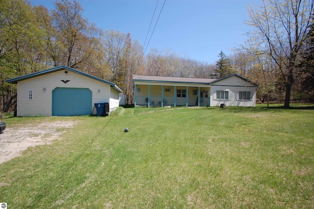 2993 N Ogemaw Trl, West Branch, MI 48661 - rear view of house featuring covered porch, a garage, an outbuilding, and a yard