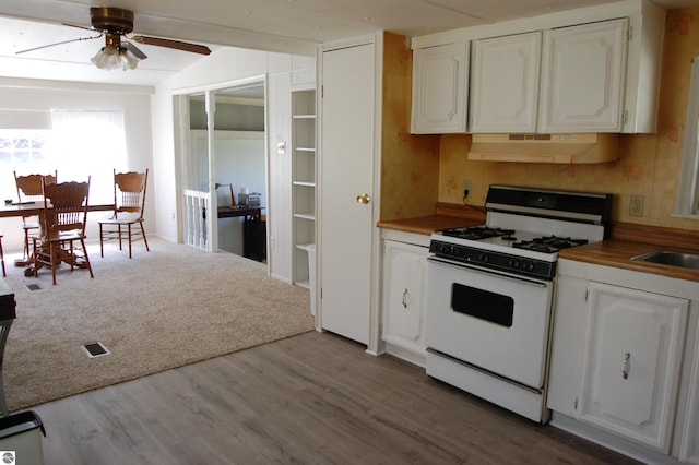 2993 N Ogemaw Trl, West Branch, MI 48661 - kitchen with white gas range oven, under cabinet range hood, ceiling fan, and white cabinets