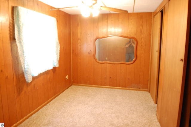 2993 N Ogemaw Trl, West Branch, MI 48661 - carpeted spare room featuring wood walls and a ceiling fan