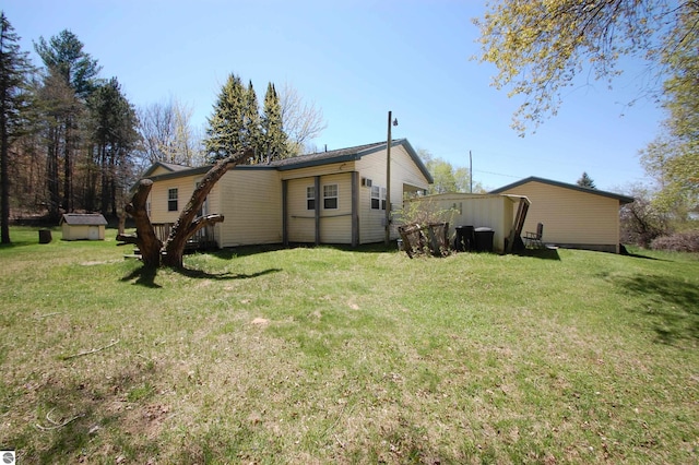 2993 N Ogemaw Trl, West Branch, MI 48661 - rear view of house with a storage shed, an outdoor structure, and a yard