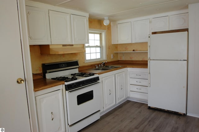 2993 N Ogemaw Trl, West Branch, MI 48661 - kitchen featuring white appliances, a sink, under cabinet range hood, white cabinetry, and dark wood-style floors