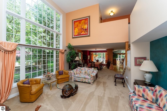 carpeted living room with baseboards and a towering ceiling