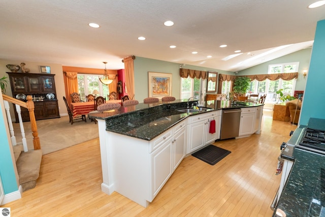 kitchen featuring appliances with stainless steel finishes, a sink, recessed lighting, light wood-style floors, and lofted ceiling