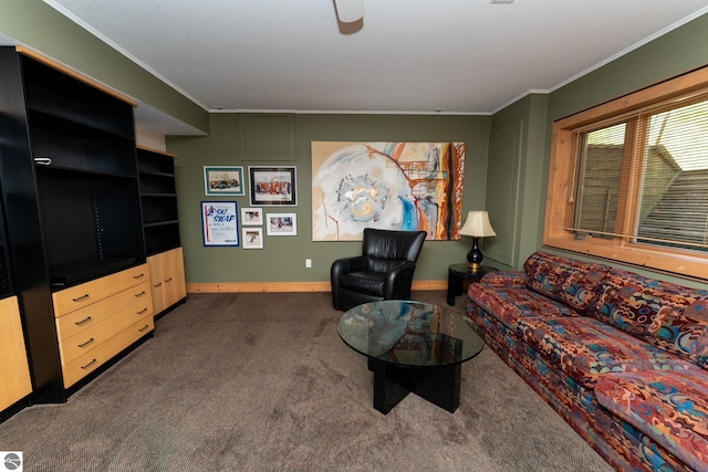 living area featuring dark carpet, ornamental molding, baseboards, and ceiling fan