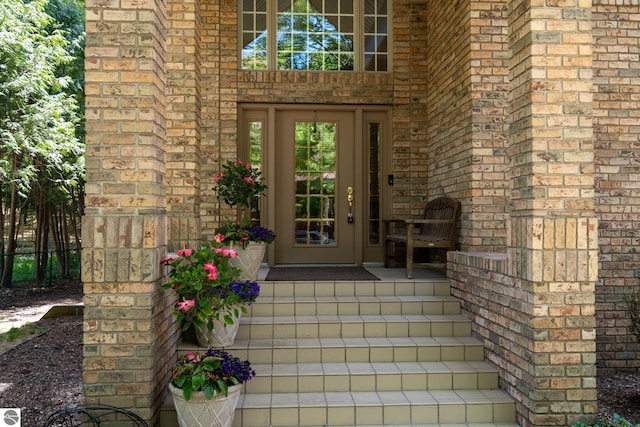 view of exterior entry with brick siding