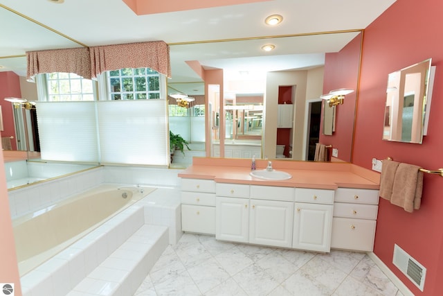 full bathroom with a garden tub, vanity, and marble look tiles