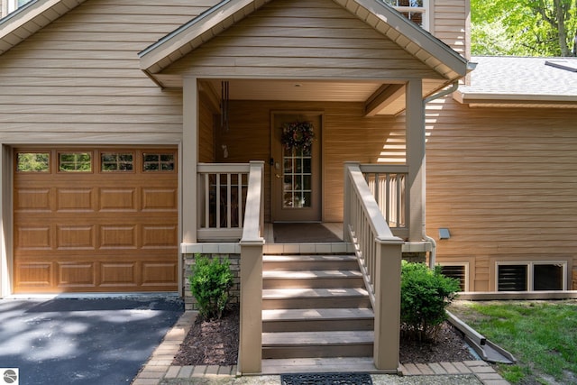 doorway to property featuring a garage and covered porch