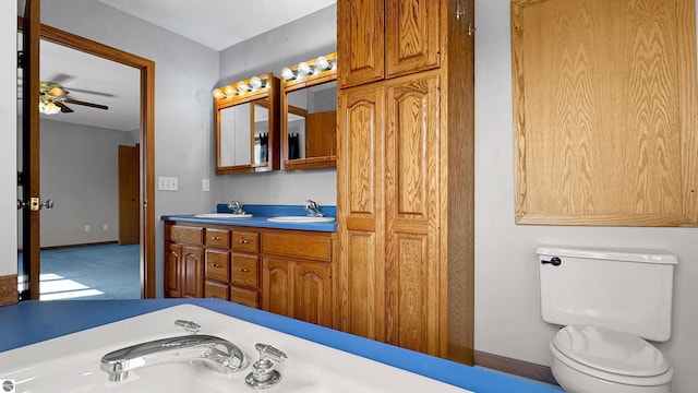 20202 50th Ave, Marion, MI 49665 - bathroom featuring toilet, a ceiling fan, and double vanity