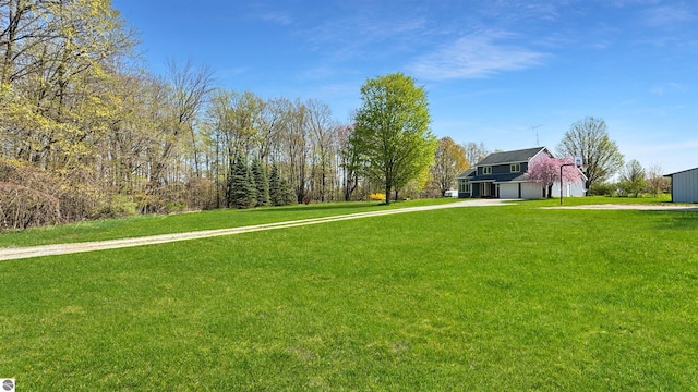 20202 50th Ave, Marion, MI 49665 - view of grassy yard featuring concrete driveway and a garage