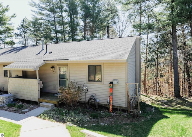 11255 E Fort Rd Unit H1, Suttons Bay, MI 49682 - view of front of house featuring roof with shingles, a front lawn, and a wooden deck