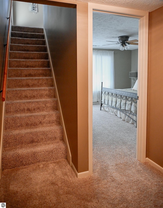11255 E Fort Rd Unit H1, Suttons Bay, MI 49682 - stairs with carpet floors, ceiling fan, baseboards, and a textured ceiling